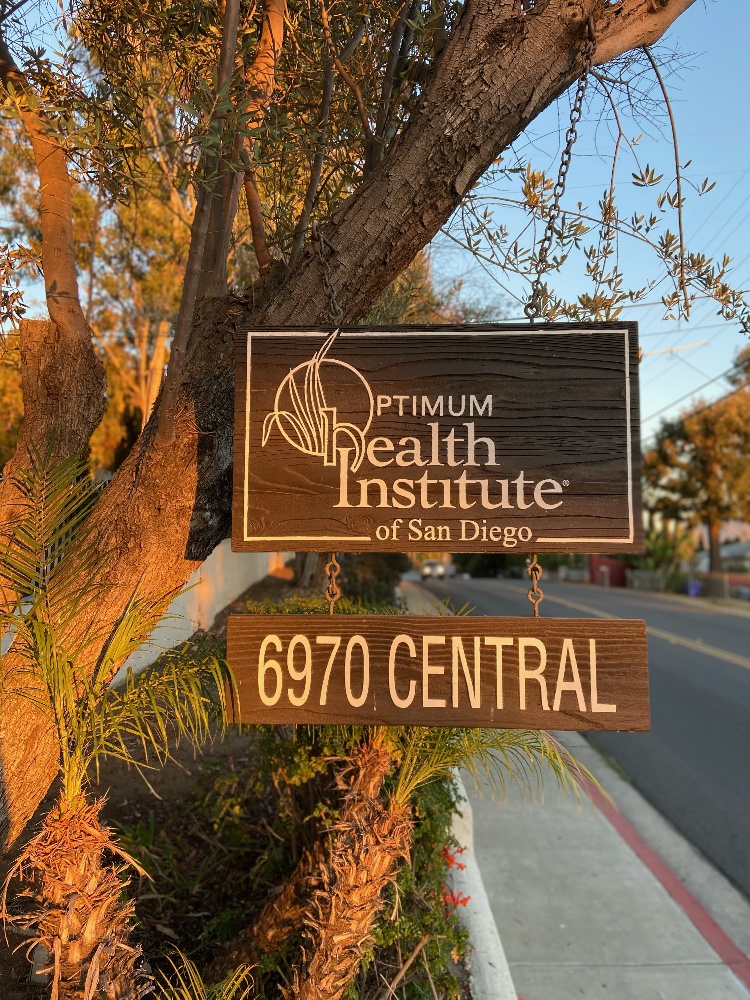 A street sign marking the location of Optimum Health Institute, a spiritual and wellness retreat in the US.